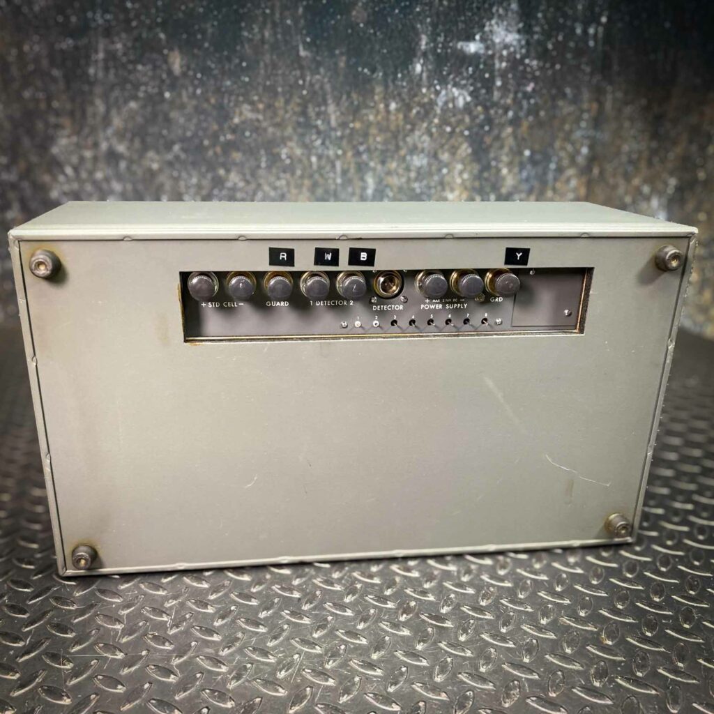 The back of the Leeds & Northrup Model 7556 Guarded Potentiometer from Obtainium Science and Surplus, showing a rectangular panel with multiple input and output connectors. The metal casing is light gray with signs of wear.