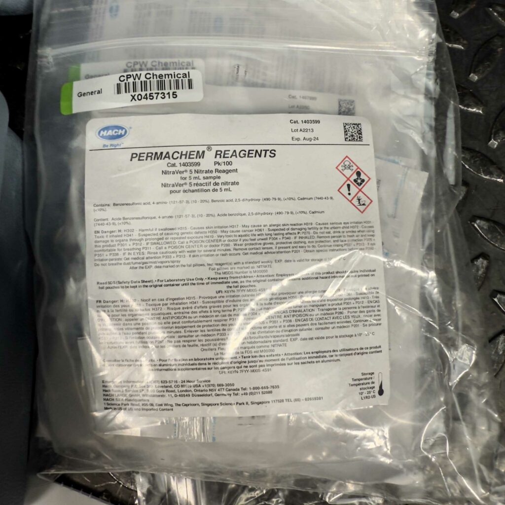 A plastic bag labeled "Permachem Reagents" inside the Hach Water Test Kit for Nitrites and Nitrates from Obtainium Science and Surplus. The label contains chemical safety warnings, instructions, and regulatory information.