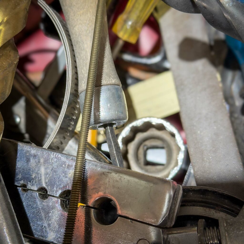 A close-up of a pile of assorted tools, including a ratchet socket, pliers, a screwdriver, and metal files. The tools are stacked haphazardly, with various metallic and plastic components visible. A sample of what MIGHT be in the Mystery Box you get from Obtainium Science and Surplus.