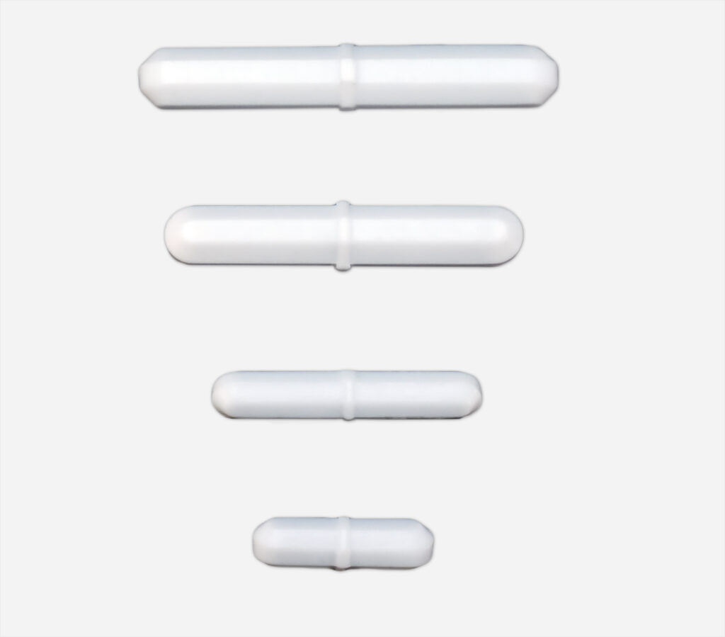 A set of four white magnetic stir bars, each with a cylindrical shape and a central pivot ring, arranged in descending order of size against a light gray background. The largest stir bar is at the top, and the smallest is at the bottom. These stir bars are commonly used in laboratory settings for mixing liquids with a magnetic stirrer